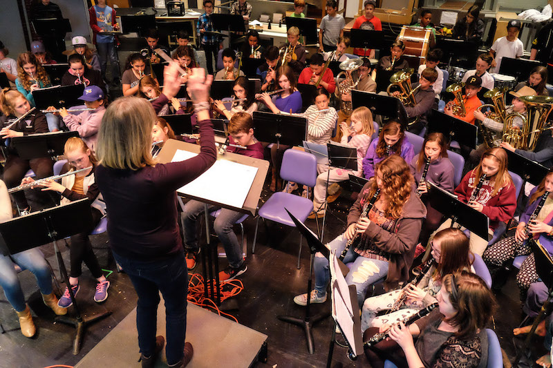 Tisbury school teacher Julie Schilling leads band in songs ranging from marches to classical pieces to pop.