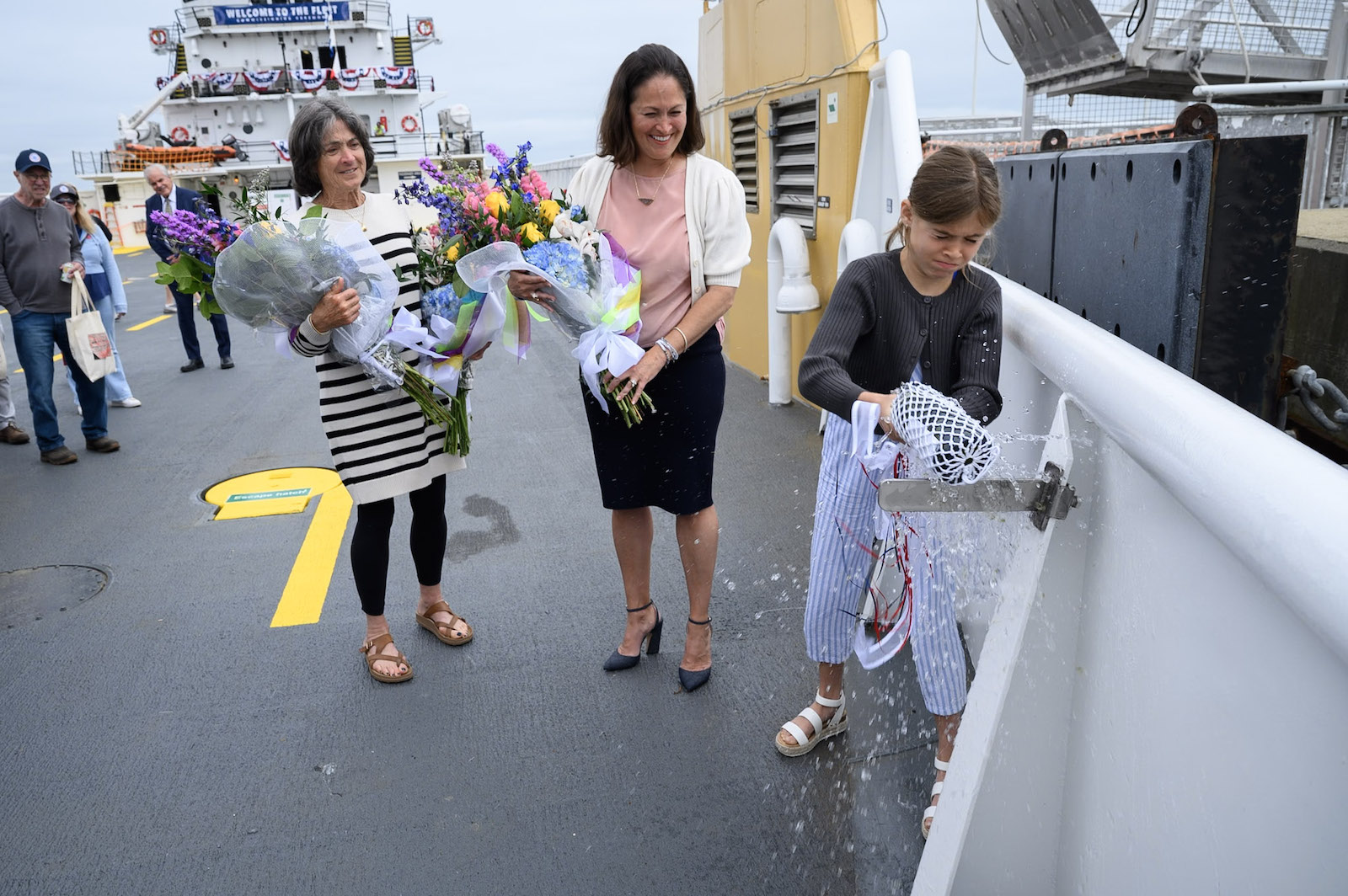 Joan Malkin, left, watches on with her daughter Jessica Mason as granddaughter Estelle Mason christens the vessel.
