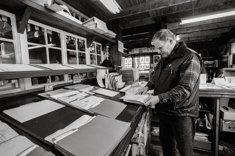 At the office, checking his ledgers.