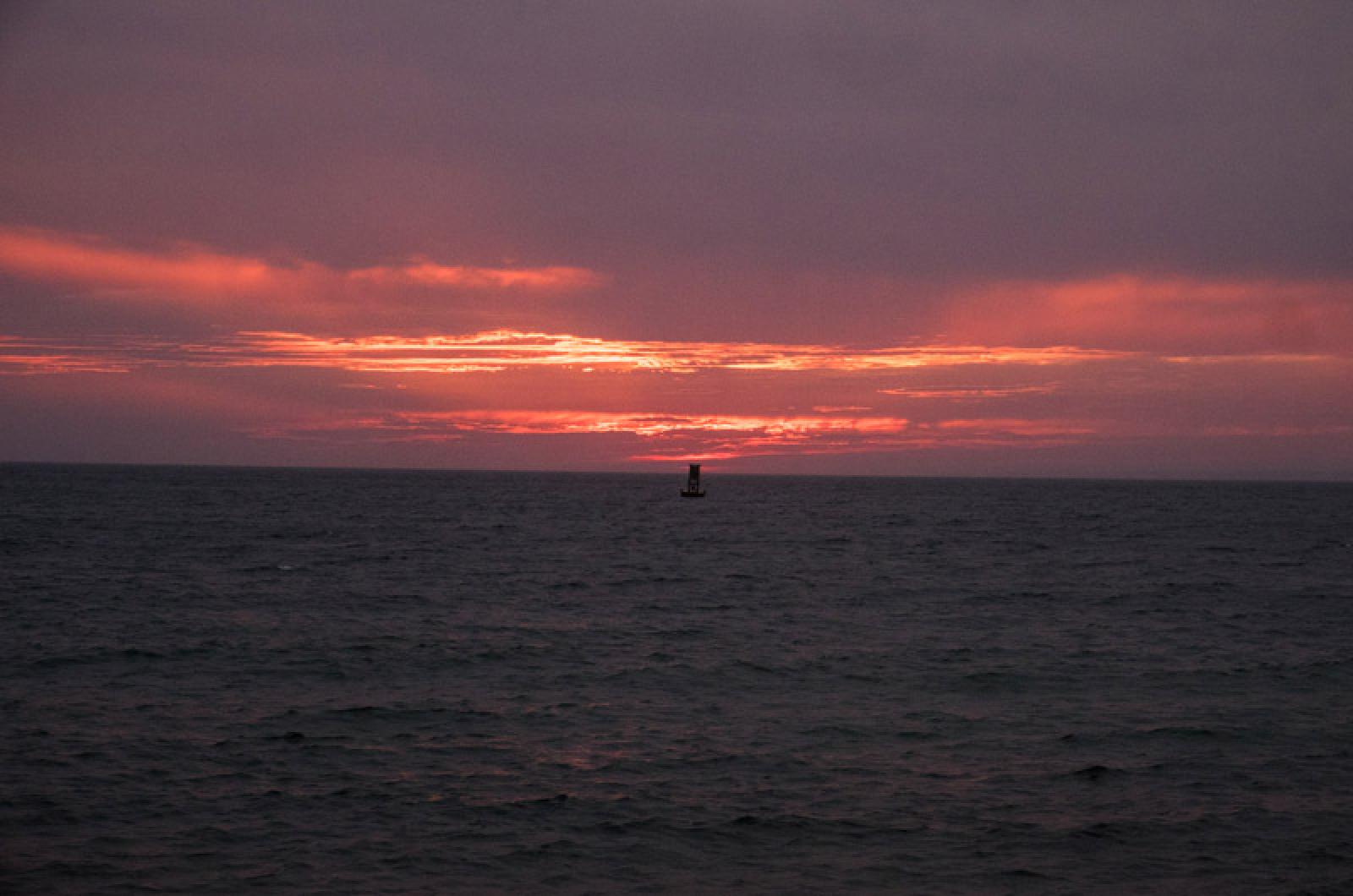 Sun sets in the west over the Menemsha buoy.