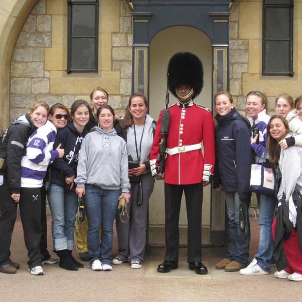 girls lacross team with british guard