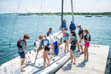 A Junior EYC crew crew taking care of a J 70 class after sailing.