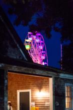 The multicolored Ferris wheel peeks out behind the barn.