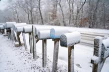 Mailboxes are covered in the early snowfall.