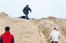 People climb over the large sand piles by the Left Fork entrance.