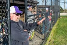 Coach Adam Cummings signals to his pitcher.