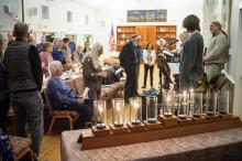 MV Hebrew Center congregation stands behind menorah.