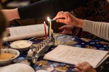 Attendees at The MV Hebrew Center Hanukkah celebration light their menorahs.