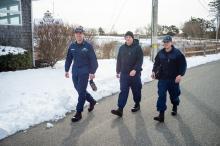 Coast Guard duty members make the walk from the station down to the boat house.