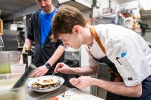 Ryan Scanlon finishing the scallop crudo with Cristopher Stam looking on.