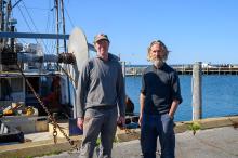 Todd and Matthew Mayhew next to the boat they co-own, the Lady M.
