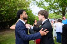 Aiden Weiland helps Jordan Souza with his tie.