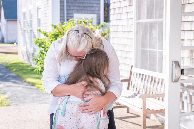 Chilmark School principal Kate Squire hugs a student.