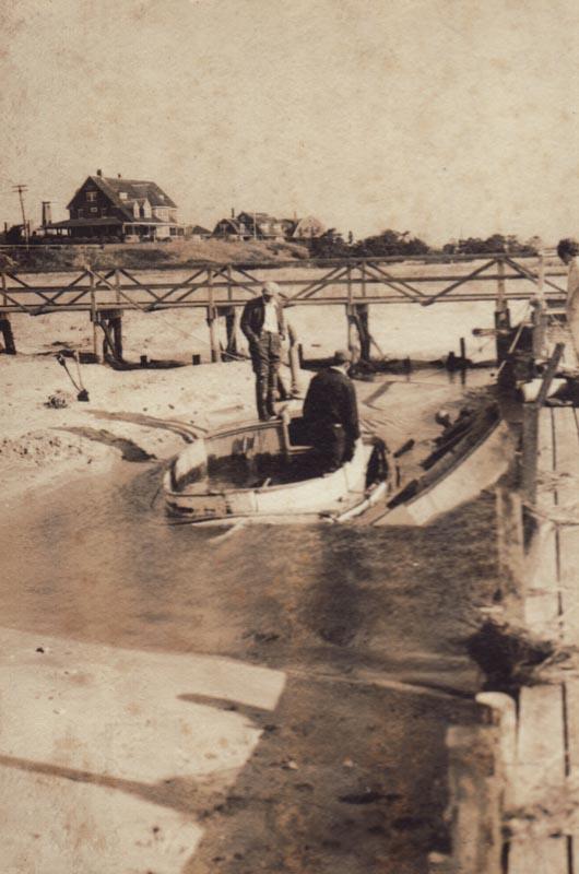 A swamped boat sits below an old wooden walkway that used to lead to the lighthouse.