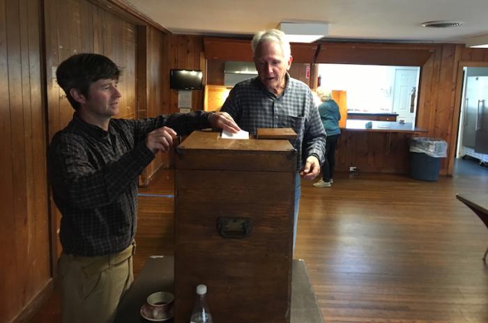 Constable Marshall Carroll 3rd helps a voter cast a ballot Wednesday at the community center.
