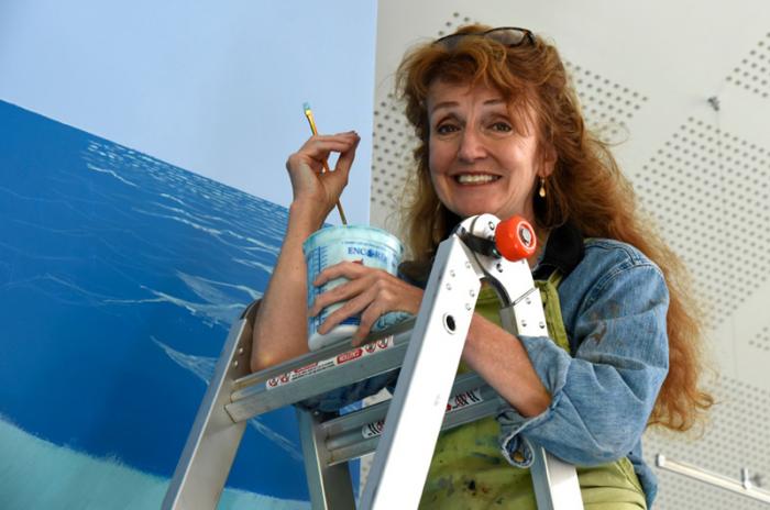 The artist at work on her latest mural in the children's room at the Edgartown Library.