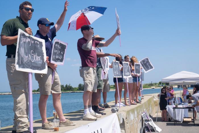 Men stood and carried signs to let women in their lives and beyond know they were there for them.