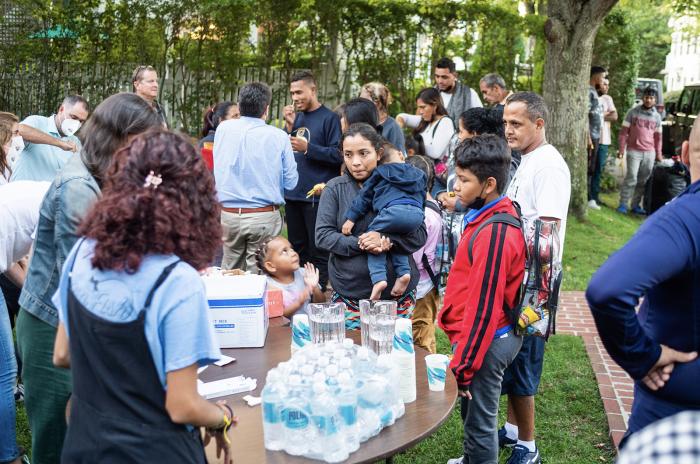Venezuelan migrants gather round a table at St. Andrew's church and parish house after being unexpectedly flown to Martha's Vineyard in September.