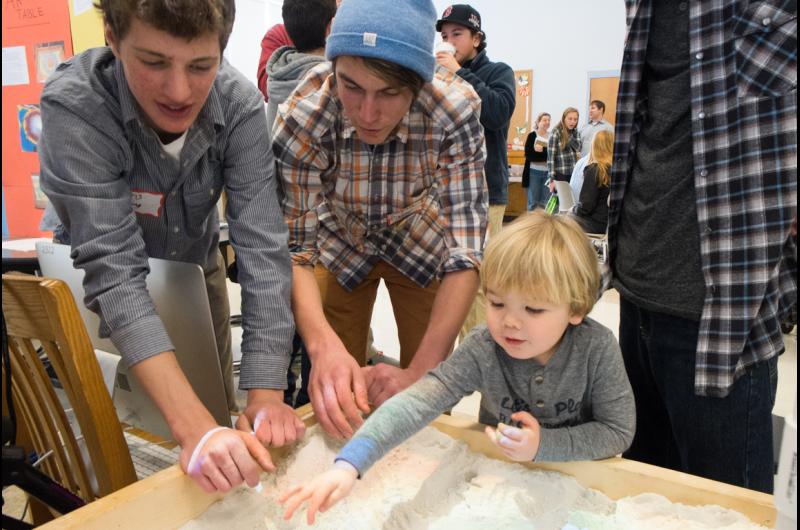 Augmented Reality Sand Table. Exhibitor left: Chris Ering. The man in the middle is Auguste Pizzano. Child on right is Griffin Niego.