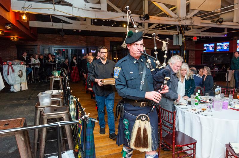 Edgartown Police Chief Bruce McNamee leads the procession of the haggis on the bagpipes.