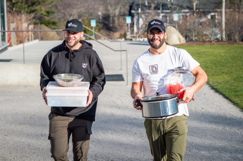 Brothers Dylan and Del Araujo carry supplies into the museum.