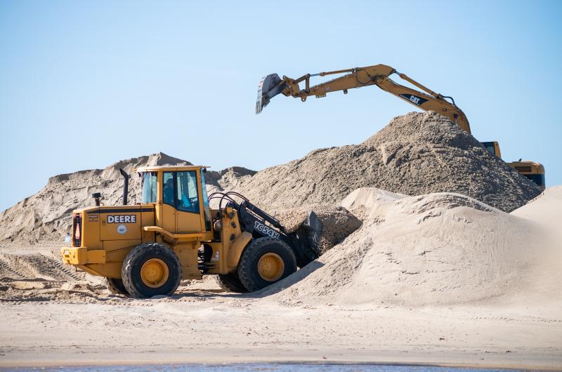 Greg Bettencourt (in the bulldozer) moves sand on the beach.