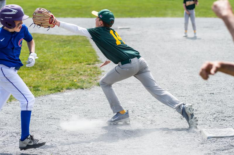 River Loughman stretches to catch the ball at 1st base.