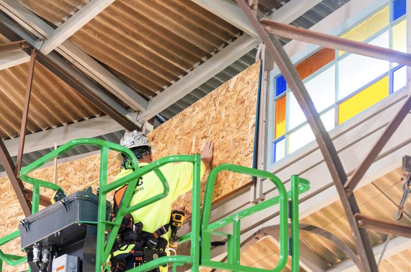 Stained glass windows are covered ahead of construction.