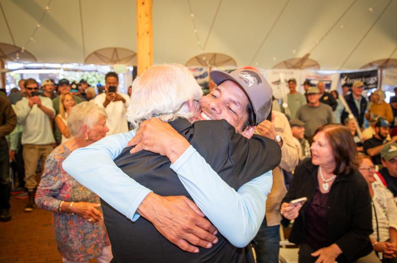 Carmelo Torres gets a hug from Mike Cassidy, who weighed in the winning fish.