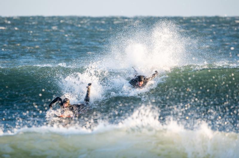 Cam Napior and Walter Greene race to catch the wave.
