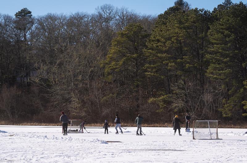 A group clears a hockey rink.