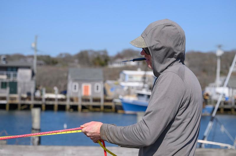 Matthew Mayhew with a net in-hand and a knife in his mouth.