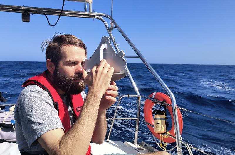 Josh Kegan navigating with a sextant.