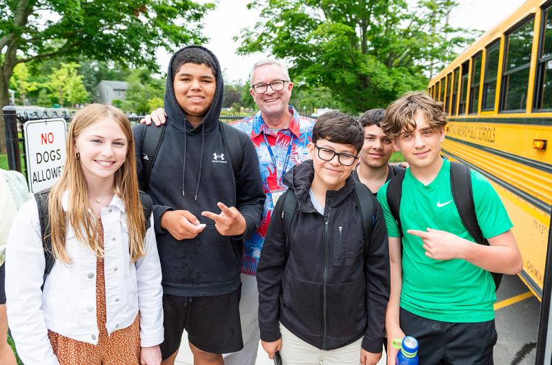 Principal John Custer poses with students.