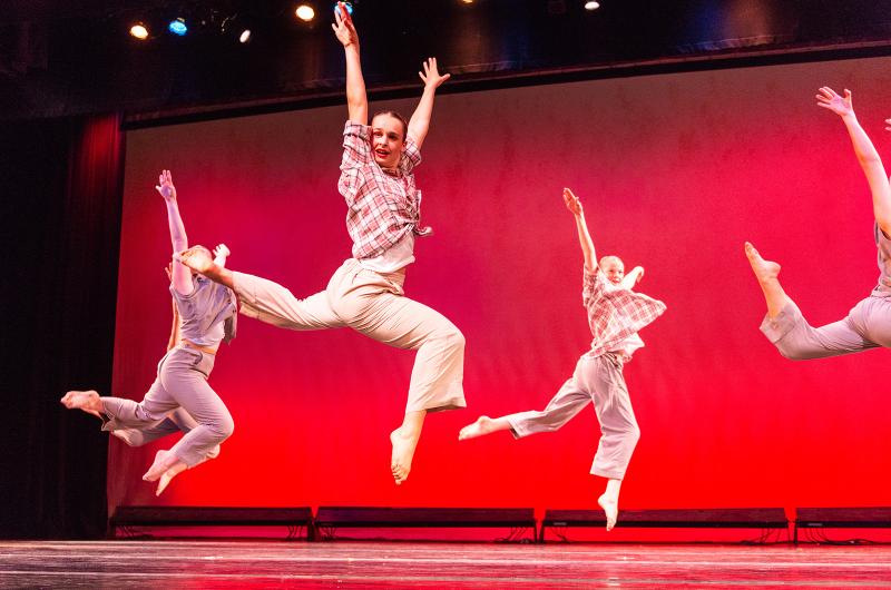 Dancers leap in time to the music.