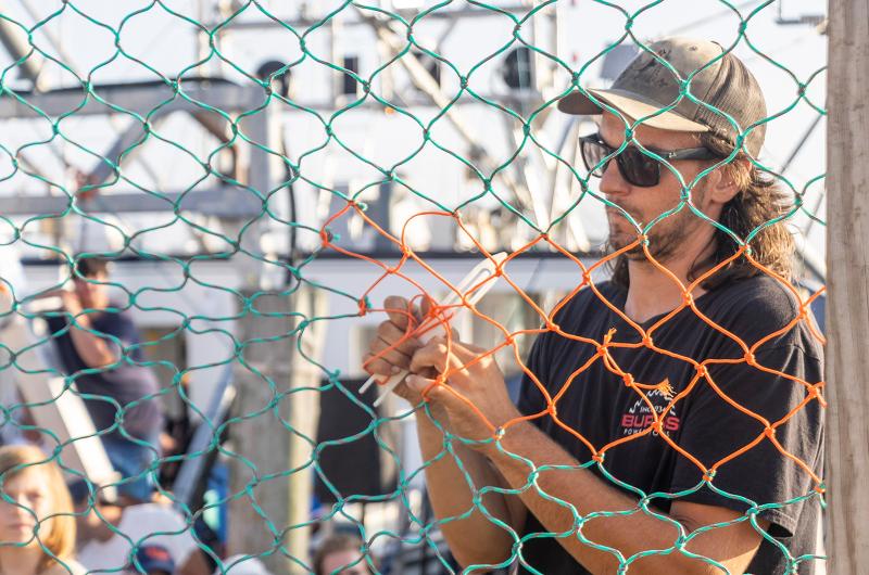 Locals show off their skill in the net mending competition.